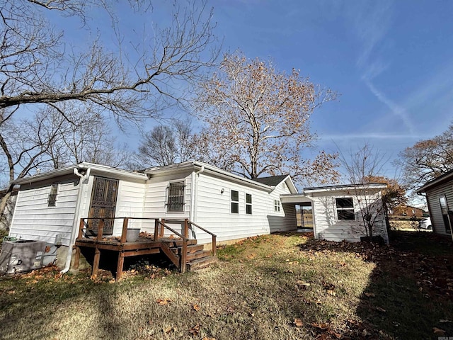 rear view of house with cooling unit and a storage shed