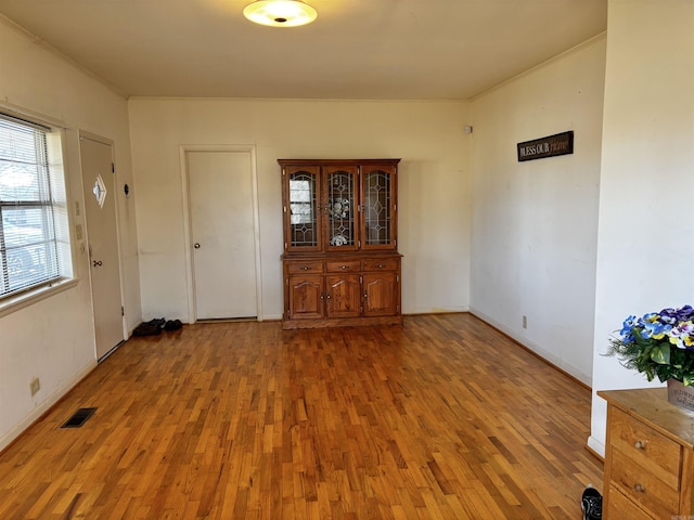 interior space featuring wood-type flooring and crown molding