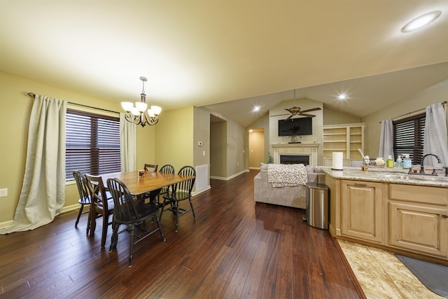 dining space featuring sink, ceiling fan with notable chandelier, dark hardwood / wood-style floors, and lofted ceiling