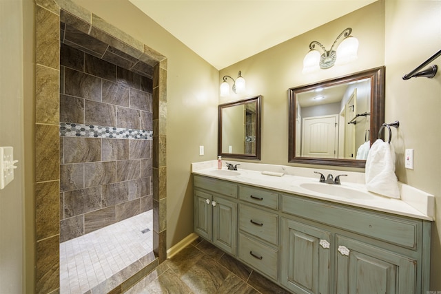 bathroom with a tile shower and vanity