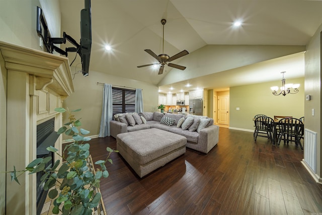 living room with ceiling fan with notable chandelier, lofted ceiling, and dark wood-type flooring