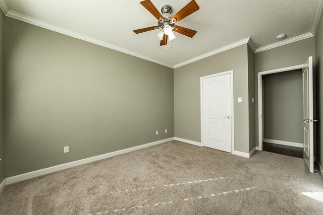 unfurnished bedroom with ceiling fan, crown molding, and carpet floors