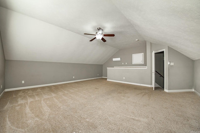 bonus room with lofted ceiling, carpet, a textured ceiling, and ceiling fan