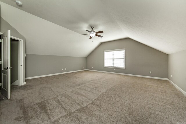 additional living space featuring carpet, vaulted ceiling, and ceiling fan