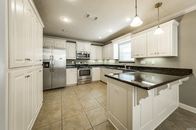 kitchen featuring white cabinetry, kitchen peninsula, pendant lighting, a textured ceiling, and appliances with stainless steel finishes