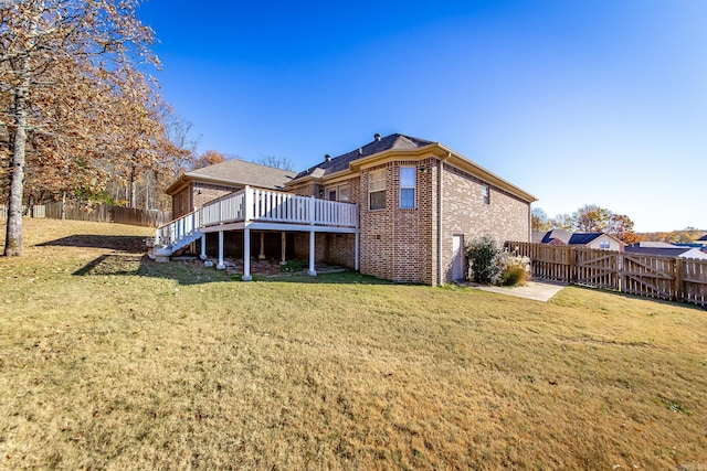 rear view of house with a lawn and a wooden deck