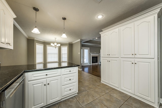 kitchen with white cabinets, pendant lighting, stainless steel dishwasher, and crown molding