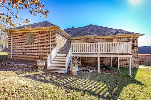 back of house featuring a lawn and a deck