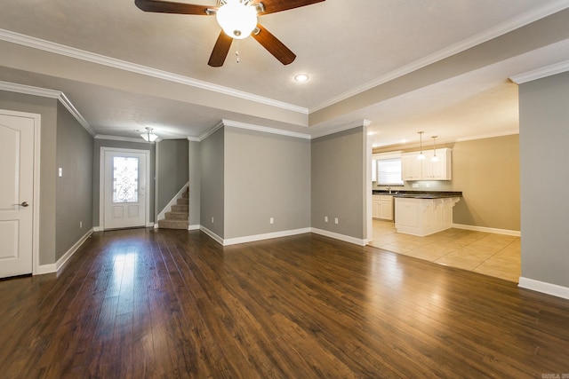 unfurnished living room with dark hardwood / wood-style floors, ceiling fan, and ornamental molding