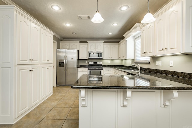 kitchen with pendant lighting, kitchen peninsula, ornamental molding, white cabinetry, and stainless steel appliances