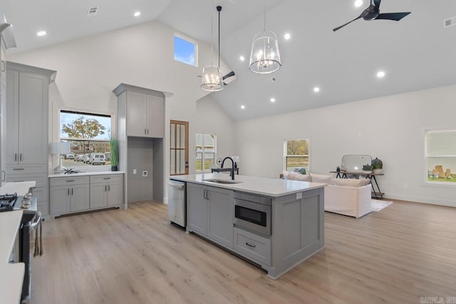 kitchen with light hardwood / wood-style floors, stainless steel appliances, sink, high vaulted ceiling, and gray cabinets