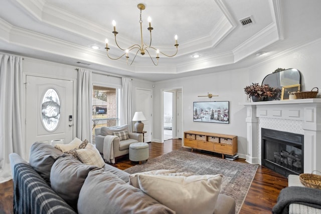 living room with dark hardwood / wood-style floors, a raised ceiling, ornamental molding, and a tiled fireplace