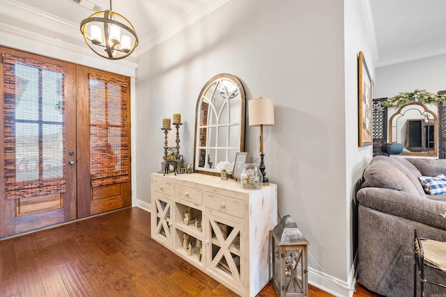 entryway featuring french doors, an inviting chandelier, dark wood-type flooring, and ornamental molding