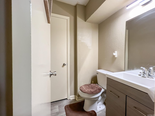 bathroom featuring vanity, hardwood / wood-style flooring, and toilet