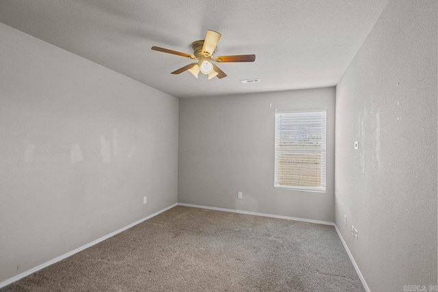 empty room featuring carpet, visible vents, ceiling fan, a textured ceiling, and baseboards