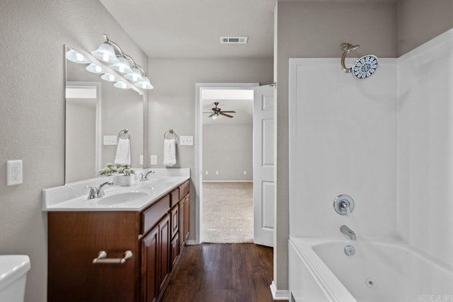 5900 Willow Way, Sherwood, AR 72117 - bathroom with wood finished floors, double vanity, a ceiling fan, and a combined bath / shower with jetted tub
