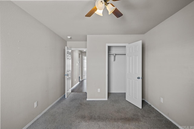 unfurnished bedroom with baseboards, ceiling fan, dark carpet, and a closet