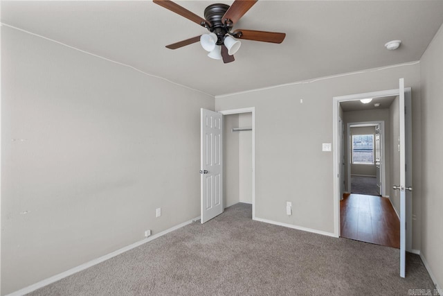 unfurnished bedroom featuring a ceiling fan, baseboards, a closet, and light colored carpet