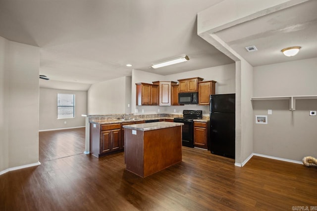 kitchen featuring brown cabinets, visible vents, a kitchen island, a peninsula, and black appliances