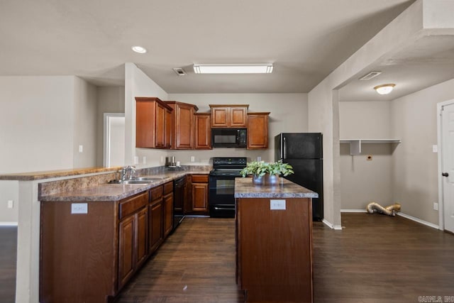 5900 Willow Way, Sherwood, AR 72117 - kitchen featuring black appliances, dark wood finished floors, a center island, brown cabinetry, and a peninsula