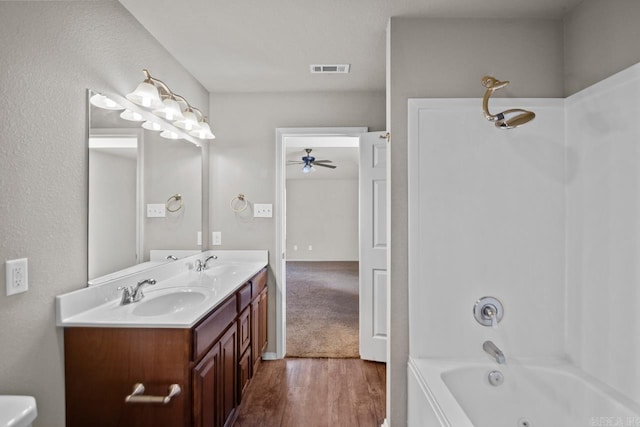 bathroom featuring shower / bathing tub combination, hardwood / wood-style floors, vanity, and ceiling fan