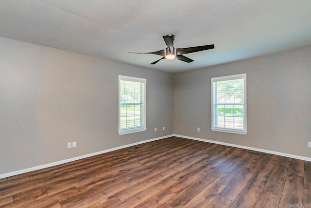 empty room featuring ceiling fan and dark hardwood / wood-style flooring