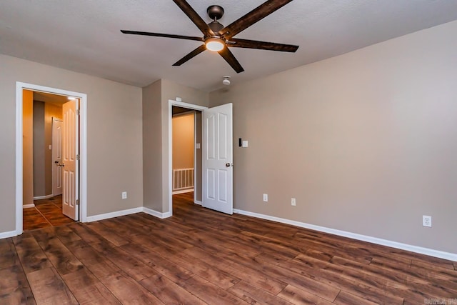 unfurnished bedroom with a textured ceiling, ceiling fan, and dark wood-type flooring