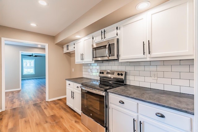 kitchen with white cabinets, light hardwood / wood-style flooring, decorative backsplash, ceiling fan, and stainless steel appliances