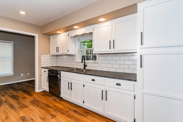 kitchen with white cabinets, black dishwasher, dark hardwood / wood-style floors, and sink