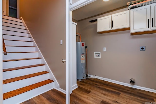 washroom featuring cabinets, dark hardwood / wood-style floors, electric dryer hookup, and water heater