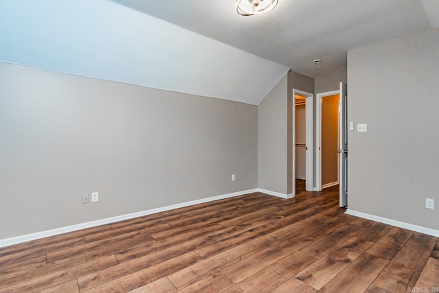 additional living space with vaulted ceiling and dark wood-type flooring