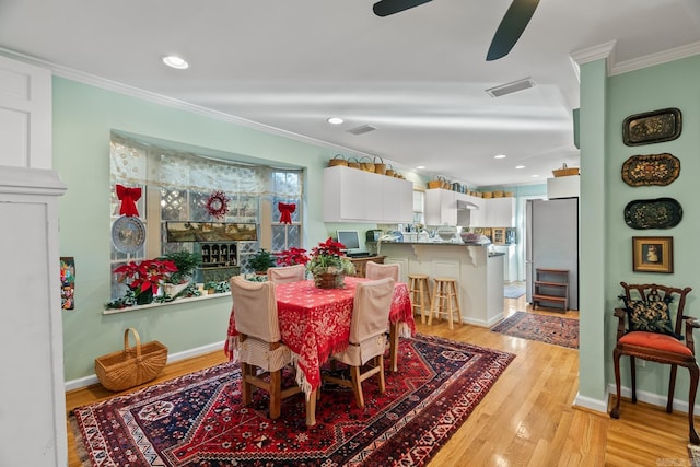 dining space featuring crown molding, light hardwood / wood-style flooring, and ceiling fan