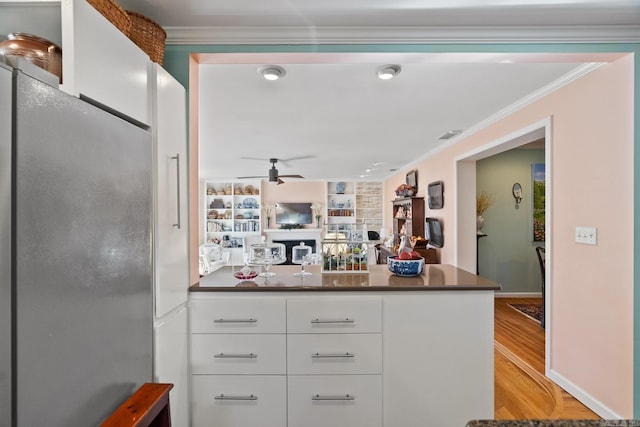 kitchen with stainless steel refrigerator, ceiling fan, light hardwood / wood-style flooring, crown molding, and white cabinets