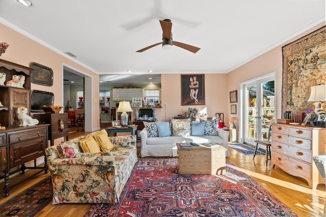 living room with hardwood / wood-style flooring, ceiling fan, and crown molding