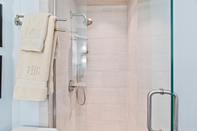 bathroom featuring toilet and a shower with shower door