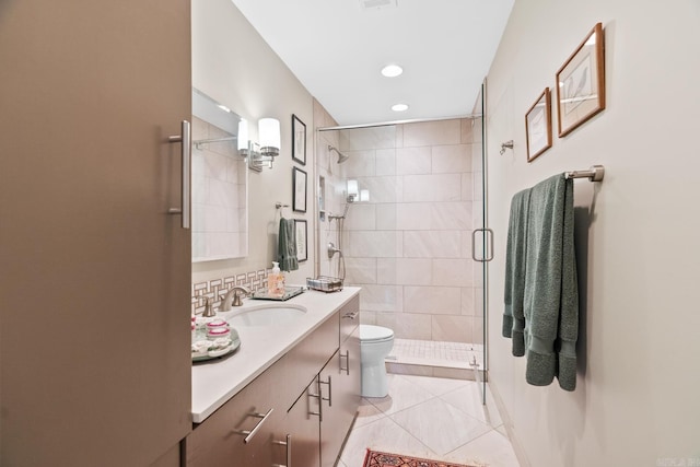 bathroom with tile patterned flooring, vanity, a shower with door, and toilet