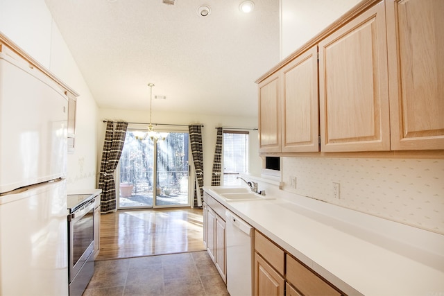 kitchen featuring light brown cabinets, white appliances, sink, decorative light fixtures, and a notable chandelier