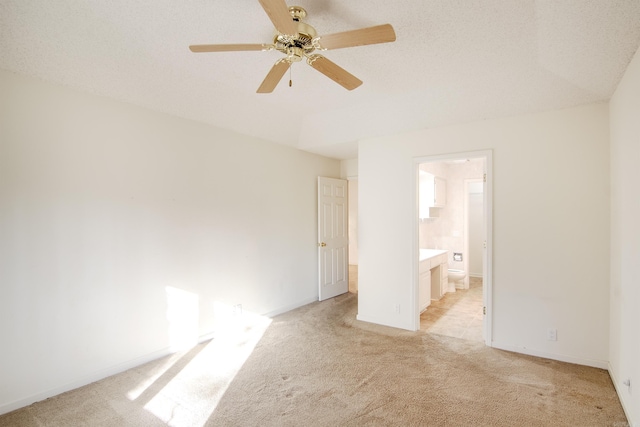 spare room with ceiling fan, light colored carpet, and a textured ceiling