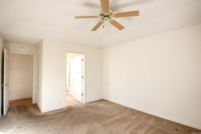 unfurnished bedroom with ceiling fan, light colored carpet, a textured ceiling, and connected bathroom