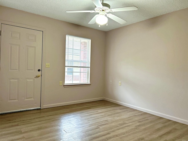 interior space featuring ceiling fan, a textured ceiling, and light wood-type flooring