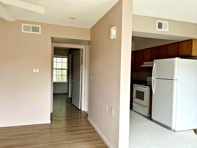 kitchen featuring white appliances, light hardwood / wood-style flooring, ceiling fan, a textured ceiling, and extractor fan