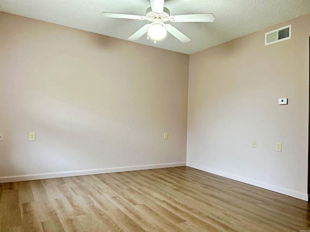 empty room with a textured ceiling, light hardwood / wood-style flooring, and ceiling fan