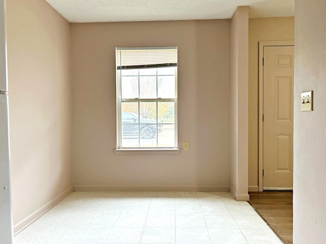 empty room featuring a textured ceiling and light wood-type flooring