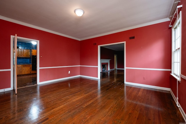 empty room featuring ornamental molding and dark wood-type flooring