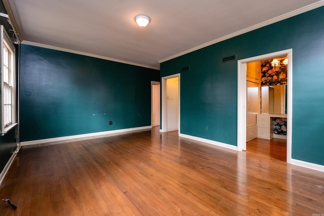 empty room featuring hardwood / wood-style flooring and crown molding