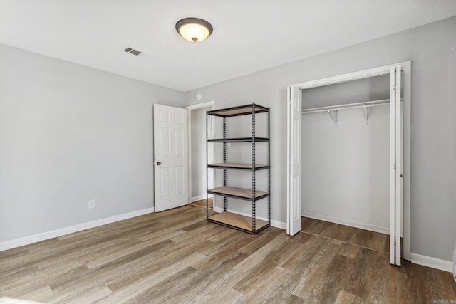 unfurnished bedroom with wood-type flooring and a closet