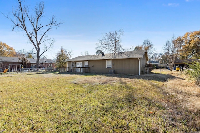 back of house with a lawn and a deck