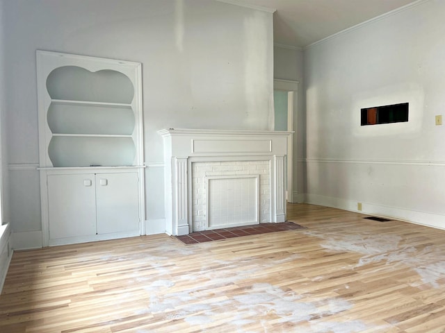 unfurnished living room featuring crown molding and light hardwood / wood-style flooring