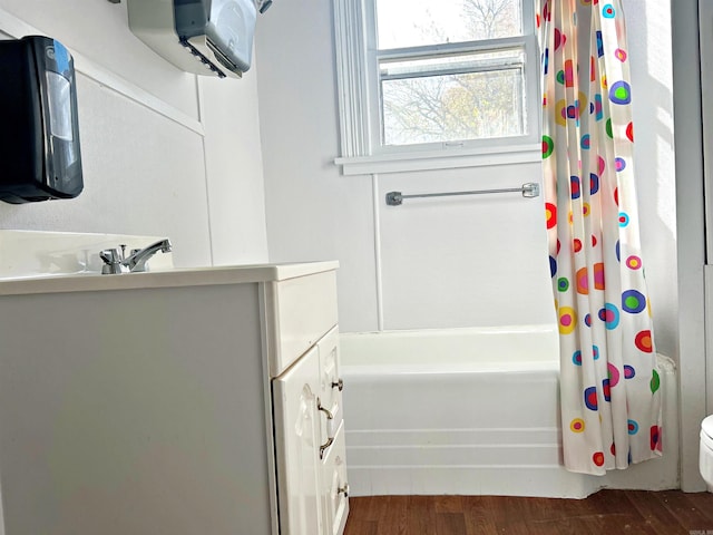 full bathroom featuring hardwood / wood-style floors, vanity, toilet, and shower / bath combo