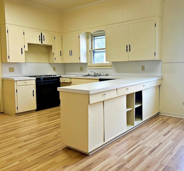 kitchen with kitchen peninsula, black stove, light wood-type flooring, ornamental molding, and sink